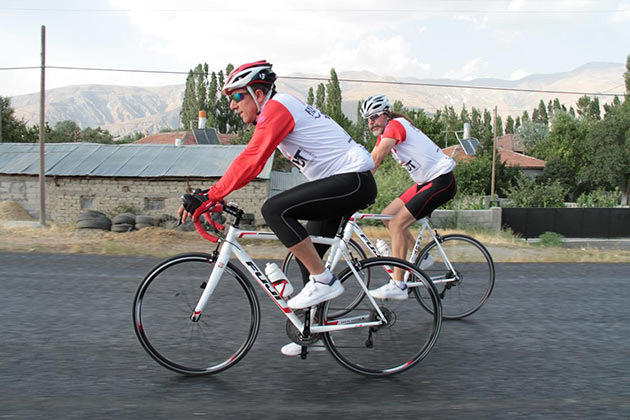 kırmızı beyaz kıyafetli iki bisikletci