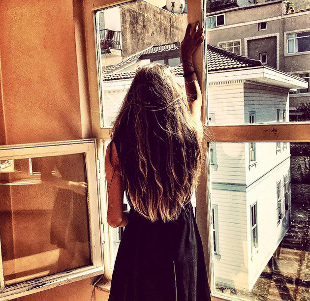 pencerenin önünde sırtı dönük ayakta duran kız