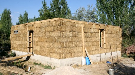 Hayalini kurduğu "saman ev"i inşa ediyor