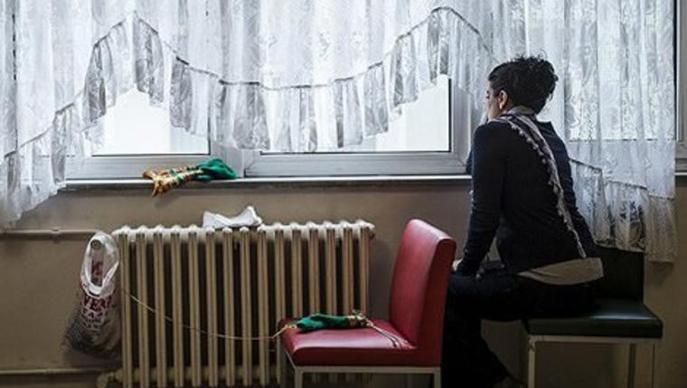Kadın konukevlerinde yaşayan bir kadın pencereden bakarken
